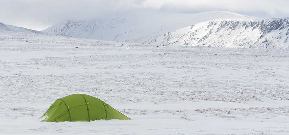Quadratic Tent with snow ridges behind