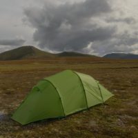Quadratic tent pitched on a plateau with dark clouds